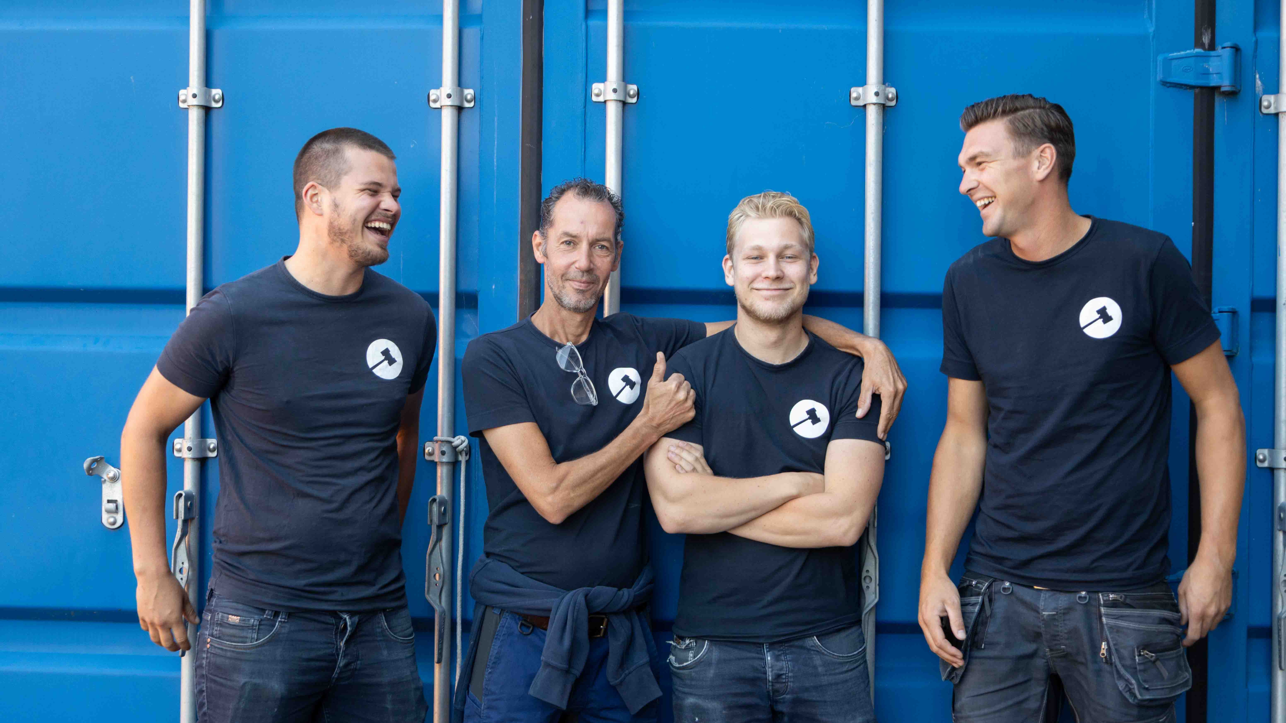 foto 4 lachende collega's voor blauwe container