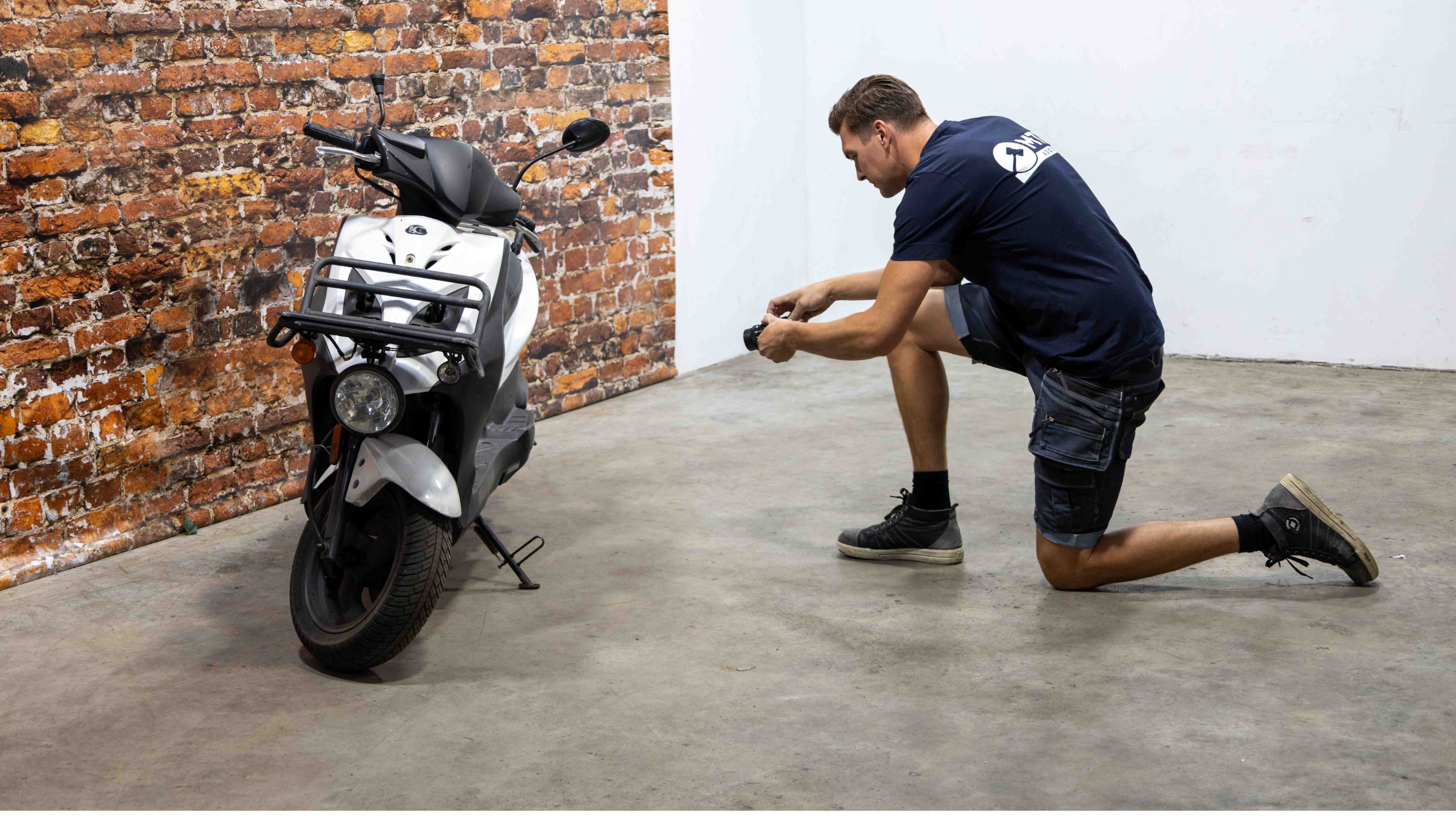 foto medewerker die een scooter op de foto zet voor veiling
